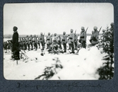 Militärer står på rad i givakt under övning i Överkalix, 1913