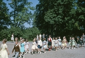 Barn går i led till skolsalen på skolavslutning i Brevens bruk, 1963