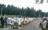 Följe med kransar till midsommarstången i Brevens bruk, ca 1967