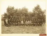 Ett kompani med sina officerare (från Kronobergs regemente?) har samlats utomhus för fotografen.
Mannarna är klädda i m/10 och m/95.
Ca 1915.