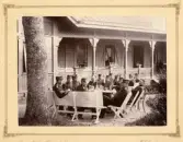 En grupp officerare har tagit en kaffepaus m.m. i eftermiddagshettan utanför en officersmäss.
Skjutskolan, Rosersberg (?).
Ca 1895.
