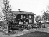 Familj på veranda till bostadshus på okänd plats i Kronobergs Län, ca 1900-1910.