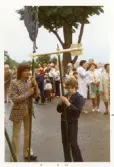 Pojkar bär symbolerna Tuppen och pilen som ska dekorera midsommarstången i Brevens bruk, 1972