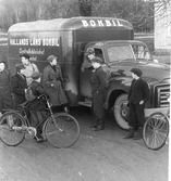 Bokbil. Gossar samlade kring Hallands läns bokbil från Centralbiblioteket i Halmstad. I Sverige startade bokbussverksamheten 1948 med en filialbuss som utgick från Borås stadsbibliotek. Året därpå utgick den första länsbokbussen från Halmstad. På 1950- och 1960-talen använde länsbiblioteken bokbussarna främst för att transportera ut böcker till filialbibliotek och utlåningsstationer. I slutet av 1950-talet fanns länsbokbussarna i 18 av 24 län.

