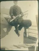 Ombord på fartyg. Man med gevär