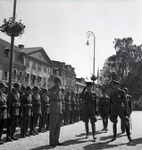 Mottagande av kronprins Gustaf Adolf med gemål Louise
på stationen i Växjö, i samband med jubileumsutställning m.m.
Kronprinsen inspekterar hederskompaniet på järnvägsplanen. 

Gustaf VI Adolf (1882-1973), reg. 1950-1973.
G.m. 2:o Louise, f. Mountbatten (1889-1965).