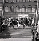 Jubileumsutställningen. Kronprinsparet Gustaf Adolf och Louise lämnar utställningen
på Växjö Högre Allmänna Läroverk. Bakom dem syns bl a landshövding
August Beskow. Nedanför trappan paraderar en del av scoutkåren i Växjö.