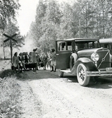 Skogis-elever och banditer vaktar flickor bakom banditchefens bil, 1945