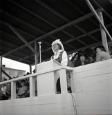 Lantbruksutställning 1942.
En kvinna i Värendsdräkt talar från talarstolen på hedersläktaren.