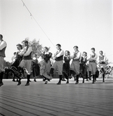 Jubileumsutställning. 
Folkdansuppvisning. Ett foldanslag i Värendsdräkt m.m. visar upp
sig på en dansbana.