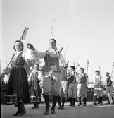 Jubileumsutställning. 
Folkdansuppvisning. Ett folkdanslag i Värendsdräkt m.m. visar upp
sig på en dansbana.