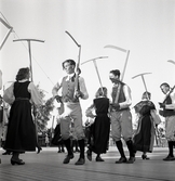 Jubileumsutställning. 
Folkdansuppvisning. Ett folkdanslag i Värendsdräkt m.m. visar upp
sig på en dansbana.