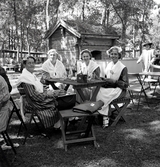Ett antal kvinnor i husmorsdräkt har samlats för läskpaus vid serveringen
i Strandbjörket.