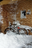Utanför hus i bostadsområdet vid Höjdgatan i Mölndal efter snöstormen den 17 november 1995. Intill husväggen står en cykel parkerad.