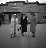 Några uppklädda damer har ställt upp sig framför järnvägsstationen i Växjö, i samband med skolträff på Flickskolan. 
I mitten syns dåv. rektorn, Eva Lundgren.