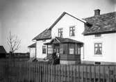 Man på trappan framför bostadshus, ca 1900.