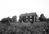 August Johnsson med familj vid sitt hus i Urshult, ca. 1900.