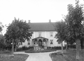 Okänt bostadshus med familj på verandan, ca. 1900.