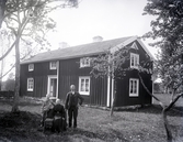 Familj framför okänt bostadshus, tidigt 1900-tal.