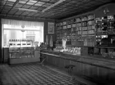 Lindgren & Brandt, 1947. Interiör med kassadisk, hyllor samt fönstret ut mot gatan.