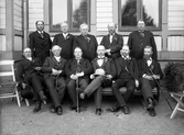 En grupp äldre män uppställda utanför Järnvägsrestaurangen i  Växjö, ca. 1900. Möjligen ett studentjubileum eller liknande.