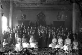 Gunnar och Agnes Andersson, trol. förlovningsfest i möjligen en frimurarloge. Växjö 1907. En stor folksamling är samlad runt dem.