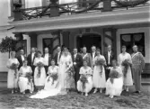 Bröllopspar och bröllopsgäster framför Bergkvara slott. Ca. 1920.