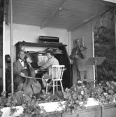 Erik Ferms trio med Gerda Zander på piano, Sigge Carl på cello och Erik Ferm som spelar fiol på musikpaviljongen i Rosenkaféet på Varbergs fästning.
Karl Fredrik Olsson var redaktör (1935-1965) på Hallandsposten så bilden har troligen varit publicerad i tidningen.