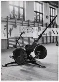 Försvarets dag 1942. Utställning i gymnastiksalen, I11.
En luftvärnskanon, 20 mm Lv kan m/40, står utställd på golvet.