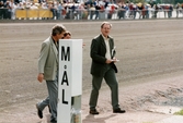 En kvinna och två män promenerar över travbanan strax intill mållinjen på Åbytravet i Åby, Mölndal, den 19 september 1998.