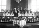 Konfirmander och präst framför altaret i Asa kyrka. ca. 1920-tal.