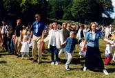 Midsommarfirande vid Gunnebo slott i Mölndal, den 20 juni 1997. Små och stora deltar i dansen kring midsommarstången.