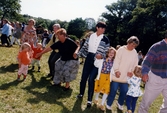 Midsommarfirande vid Gunnebo slott i Mölndal, den 20 juni 1997. Små och stora deltar i dansen kring midsommarstången.