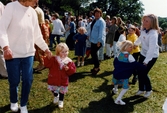 Midsommarfirande vid Gunnebo slott i Mölndal, den 20 juni 1997. Små och stora deltar i dansen kring midsommarstången.