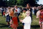 Midsommarfirande vid Gunnebo slott i Mölndal, den 20 juni 1997. Små och stora deltar i dansen kring midsommarstången.