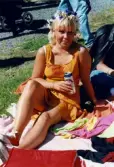 Midsommarfirande vid Gunnebo slott i Mölndal, den 20 juni 1997. Porträtt av en kvinna som sitter på en filt i gräset och har en blomsterkrans på huvudet.
