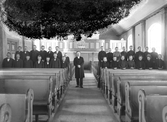 Konfirmander och präst avfotograferade i en kyrka, någonstans i Kronobergs län, ca 1908.