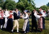 Midsommarfirande vid Gunnebo slott i Mölndal, den 20 juni 1997. Kvinnor och män iförda bygdedräkter dansar folkdans.