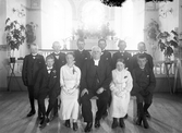 Liten grupp konfirmander och en präst, fotograferade framför altaret i en kyrka. Ca. 1914, okänd plats i Kronoberg.