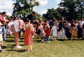 Midsommarfirande vid Gunnebo slott i Mölndal, den 20 juni 1997. Små och stora deltar i dansen kring midsommarstången.