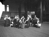 Teatergrupp eller möjligtvis en folkdansgrupp, i gymnastiksal i Växjö, ca. 1910. Möjligtvis Läroverkets gymnastiksal.