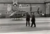 I11, den 30/1 1974.
Fem läkare med arméstabsläkare Olof Kylin i spetsen, anländer med helikopter från Stockholm för att hjälpa till med visitation/undersökning av 505 sjukanmälda.
Regementschefen överste Per Hugo Winberg avvaktar landningen.