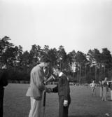 Idrottens dag på Värendsvallen. Prisutdelning. En man i träningsoverall m.m. får en silverbägare i pris.