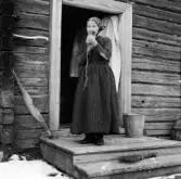 Rättvik, Ore, Dalbyn. Liss Matts Anders Erssons Anna blåser horn 1917.