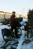 En brevbärare på cykel som delar ut post på Höjdgatan i Mölndal, december 1998.