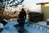 En brevbärare på cykel som delar ut post på Höjdgatan i Mölndal, december 1998.