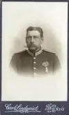 En man i full uniform med orden.
Ateljéfoto.
Musikfanjunkaren C.G. Carlsson. Född 1855.
Undersergeant, svärdsman. Avsked med pension 1905.