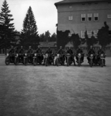 Ett antal män med motorcyklar står redo utanför en av kasernerna på I 11, Växjö.