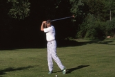 Golfspelare på golfbana tar en sving, 1989