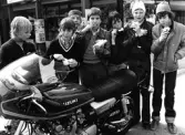 Ett gäng pojkar beundrar en motorcykel, 1970-tal